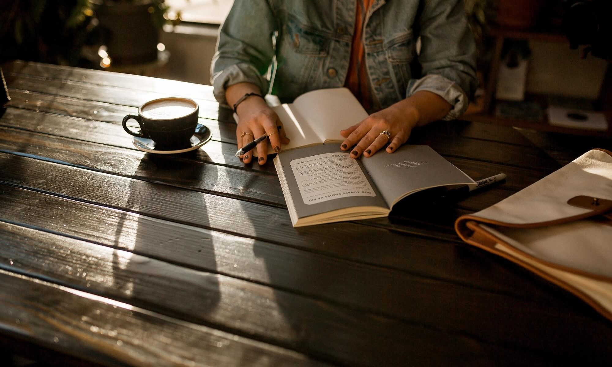 menina com livros e café