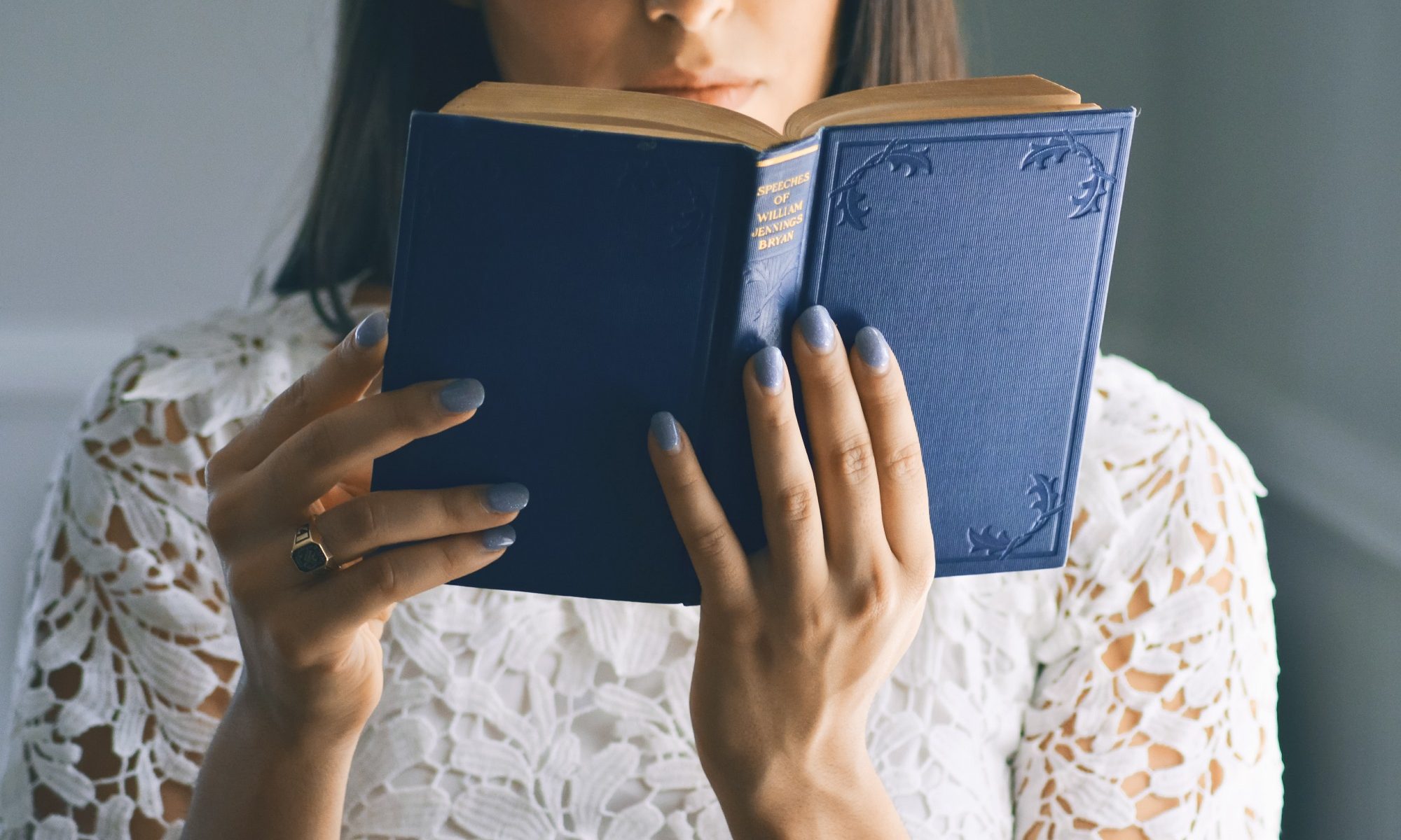 mulher segurando livro de capa azul