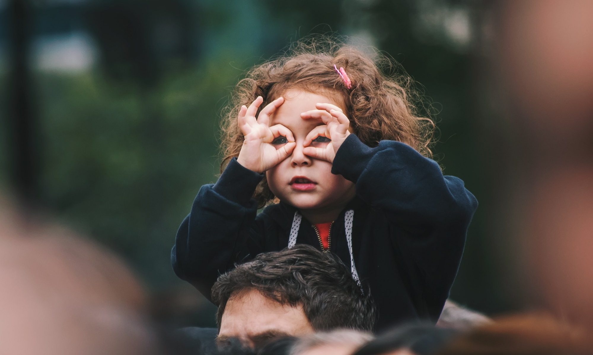 menina na garupa do pai