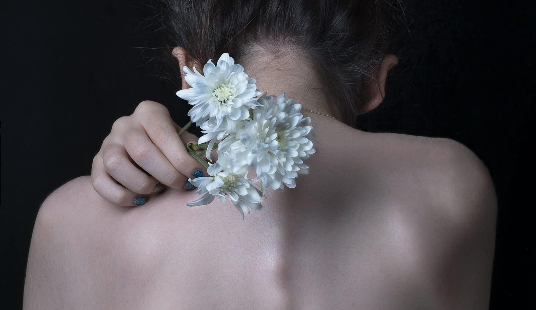 mulher de costas segurando flores