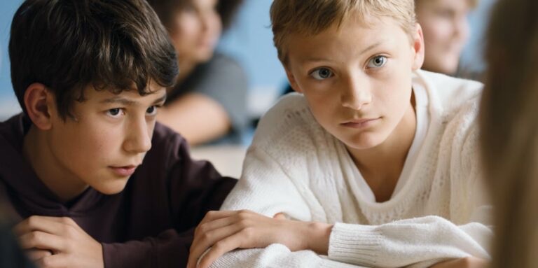 Cena dos amigos Léo e Remi no filme Close. Um está ao lado do outro, com as cabeças próximas. Léo olha para frente - direcionando o olhar a outra pessoa. Remi também, mas com a cabeça de modo mais lateral.