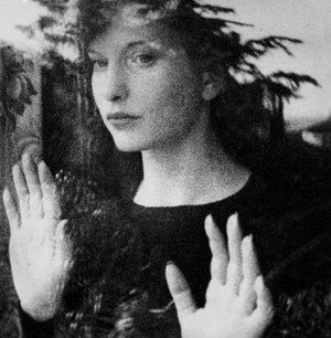 Atriz e diretora Maya Deren, retrato preto e branco em frente a um vidro